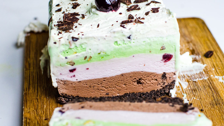 sliced spumoni ice cream cake on a wooden cutting board