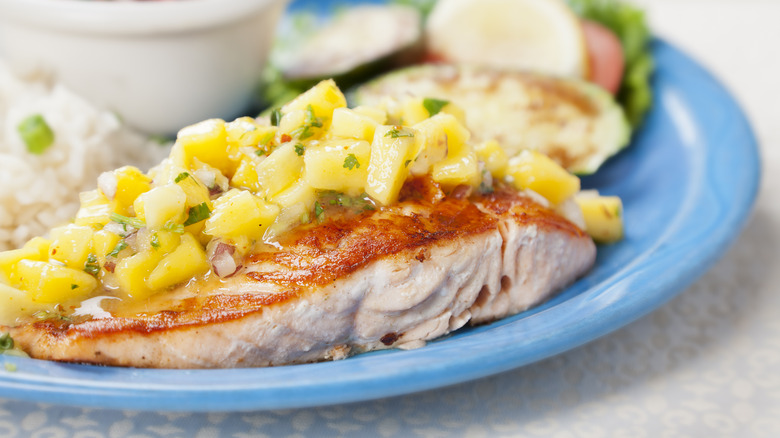 piece of fish topped with mango salsa