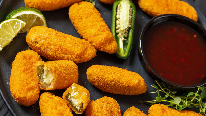 Jalapeño poppers on a plate with dipping sauce