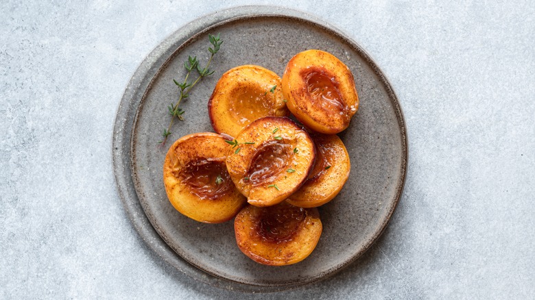 cooked peaches on a blue plate