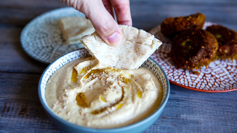 scooping hummus with pita