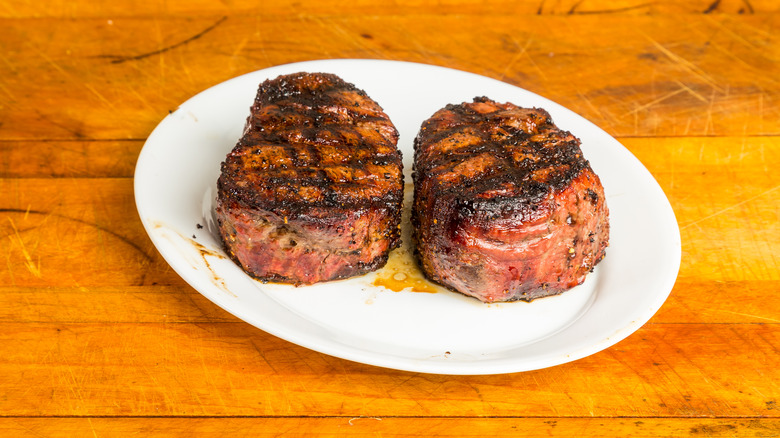 two filets resting on white plate