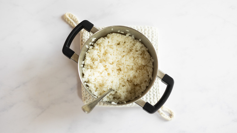 steamed rice in pot with fork 
