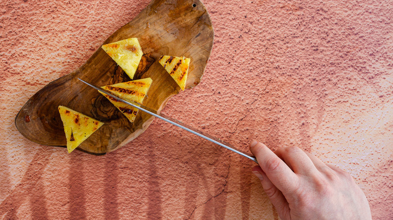 Slicing pineapple into wedges