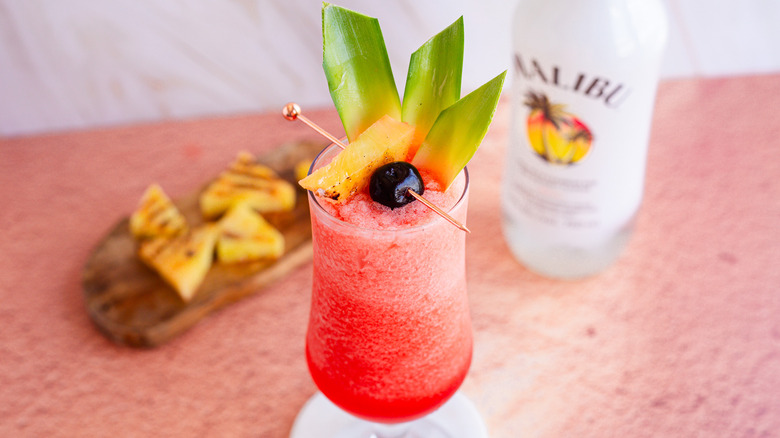 Frozen cocktail with garnish and charred pineapple in background