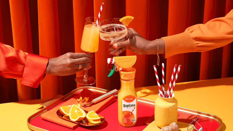 Tropicana spray bottle and people clinking mimosas