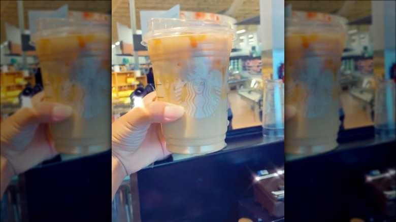 a person holding a starbucks coffee