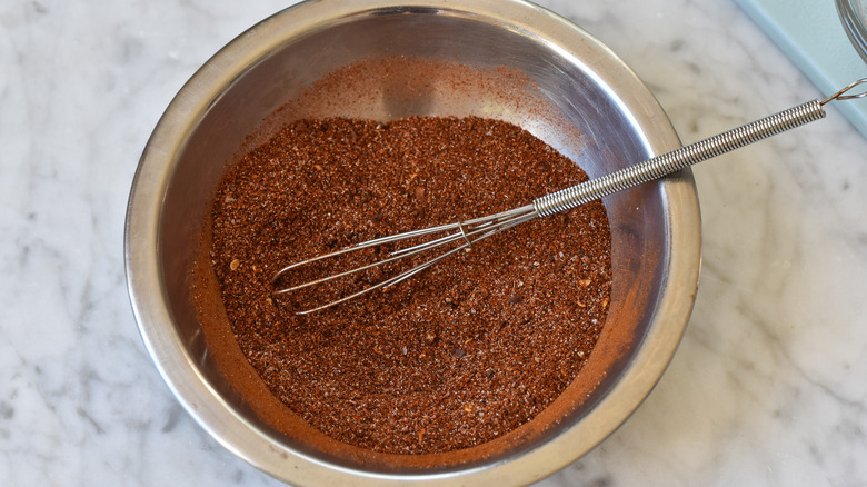 chili powder in bowl with tiny whisk