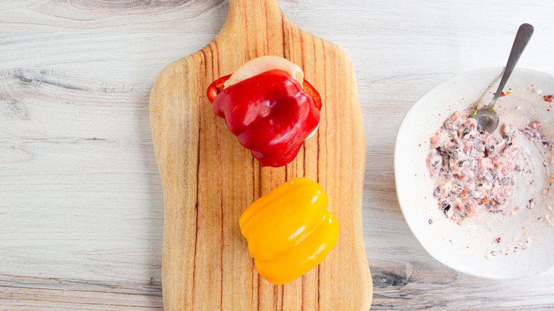 Two bell pepper sandwiches on cutting board with spread in bowl