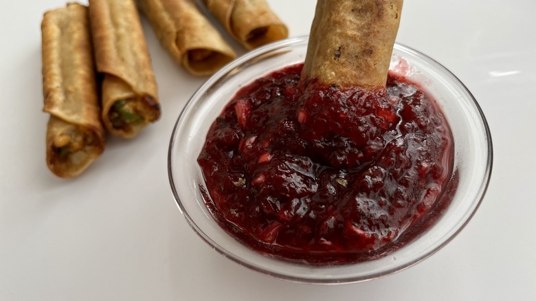 taquito dunked in cranberry salsa