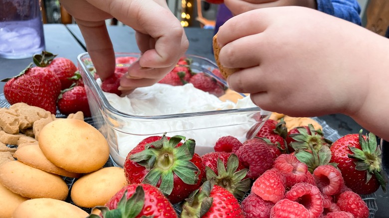 hands dipping fruit into dip