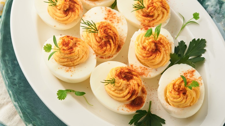 deviled eggs on a plate with chili powder