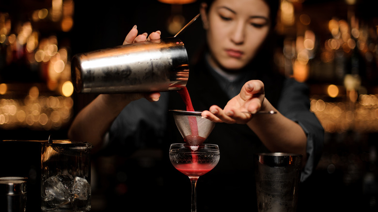 bartender straining cocktail
