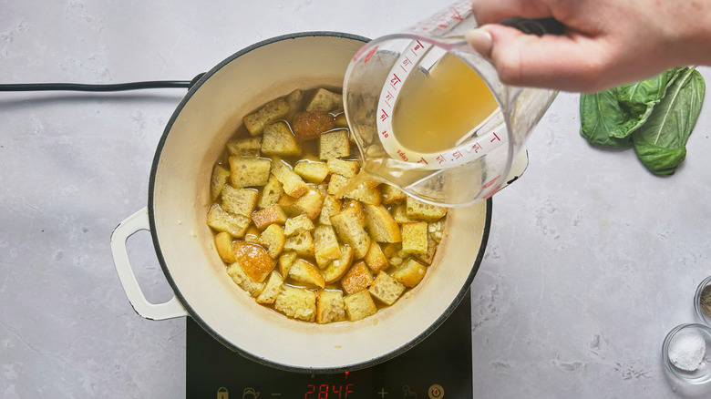 pouring chicken broth over bread