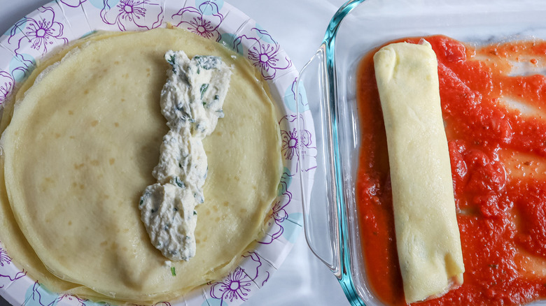 transferring crespelle to baking dish