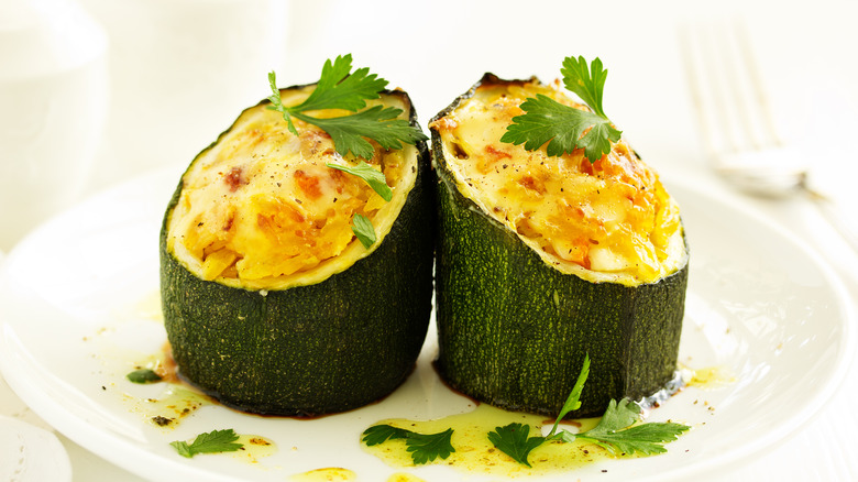 rice and cheese stuffed twice baked zucchini cylinders on a plate