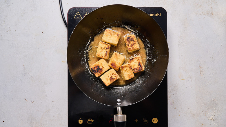 frying tofu in wok