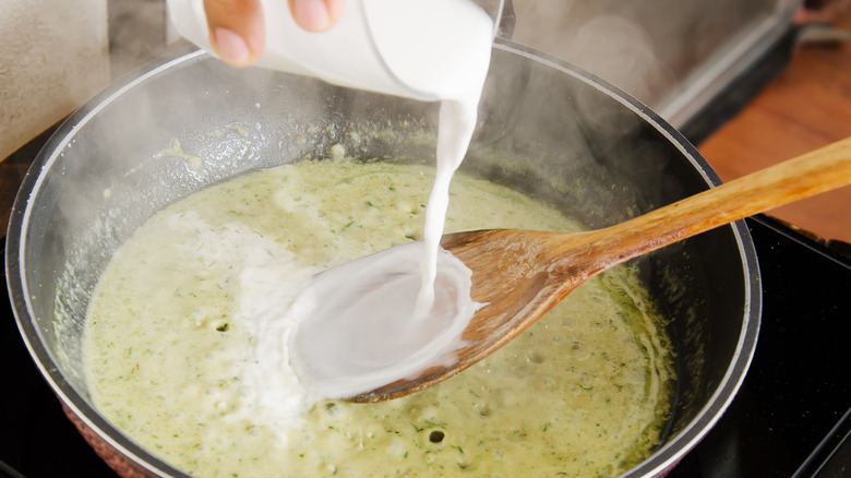 Pouring coconut milk into curry