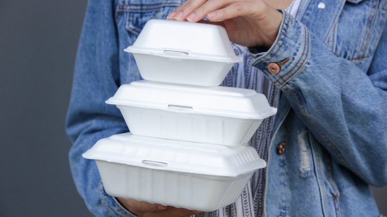 Person holding styrofoam food containers
