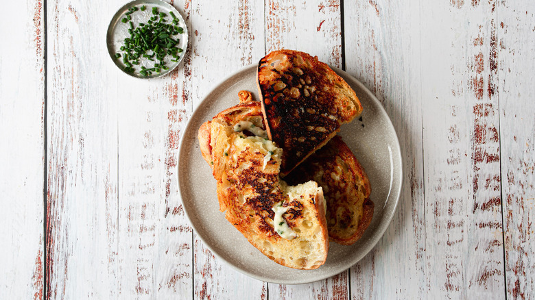 grilled cheese on a plate with chives