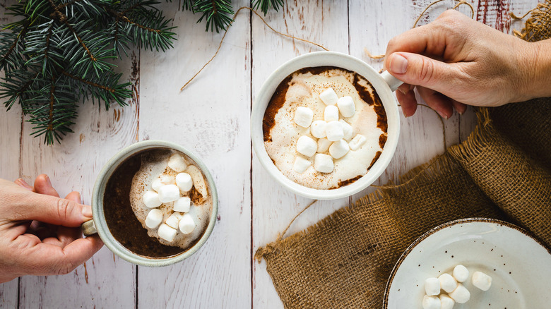 Hands holding two cups of hot chocolate