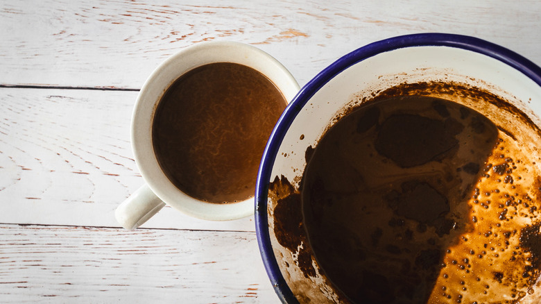 Pouring hot chocolate into mugs from saucepan