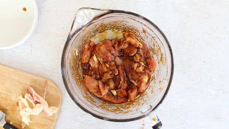 chicken marinating in a bowl