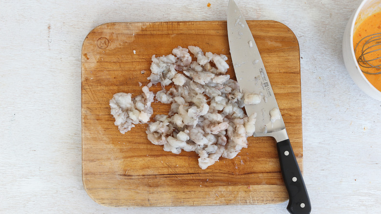 chopped shrimp on cutting board with knife