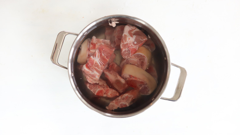 pork bones covered with water in a pot