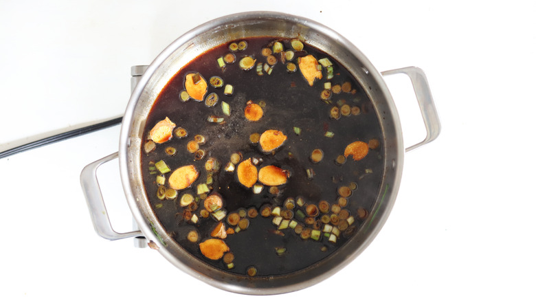 Soy sauce and aromatics in saucepan