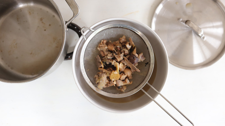 pork bone broth strained in sieve