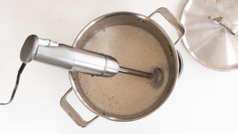 immersion blender in a pot of broth