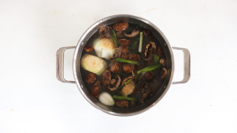 vegetables and pork bones in pot of water