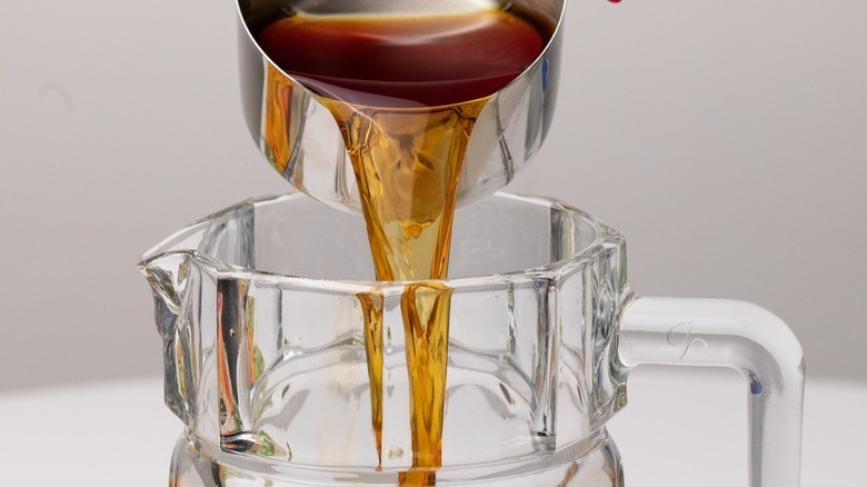 pouring brown liquid into pitcher