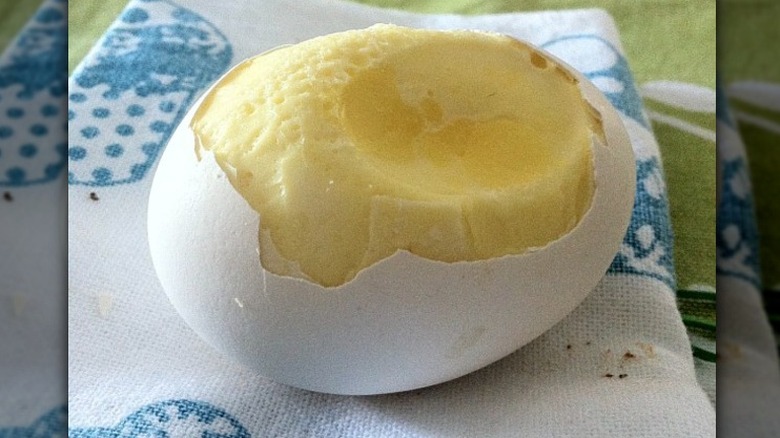 Partially peeled egg scrambled in sheel