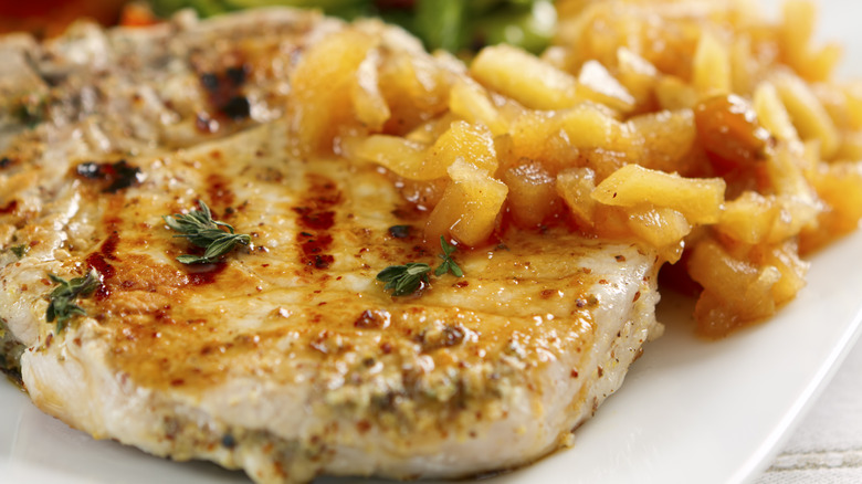 Close-up of pork chops served with apple sauce