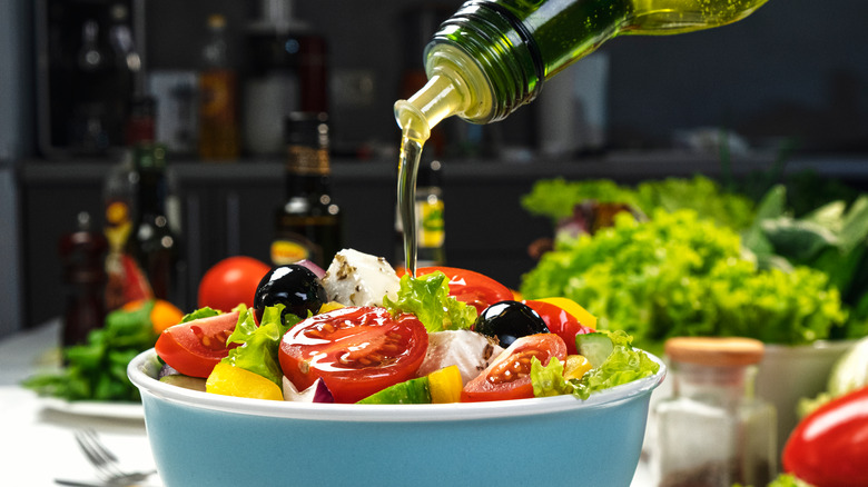 Pouring olive oil on salad