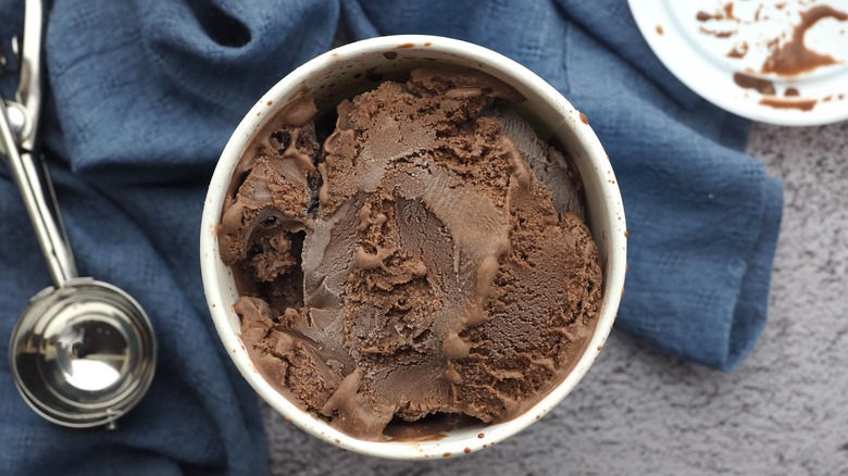 Aerial view of chocolate ice cream pint and scooper