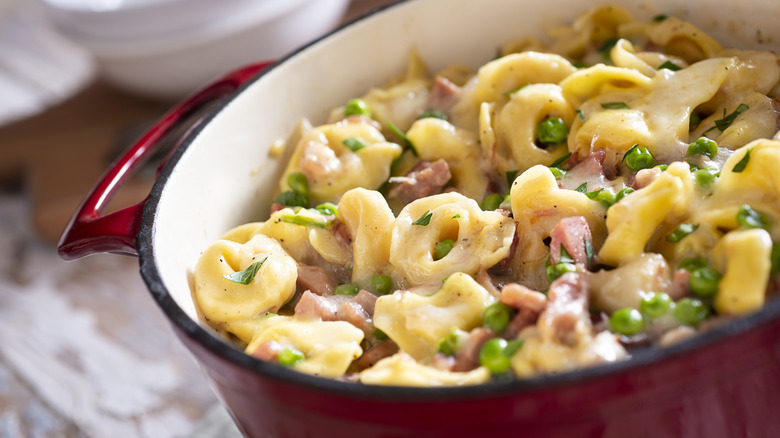Tortellini with peas and meat in a pot
