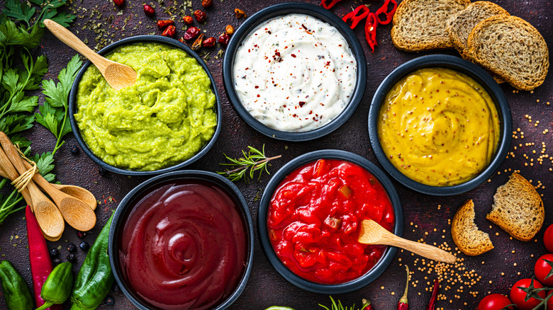 Five colorful dipping sauces in bowls