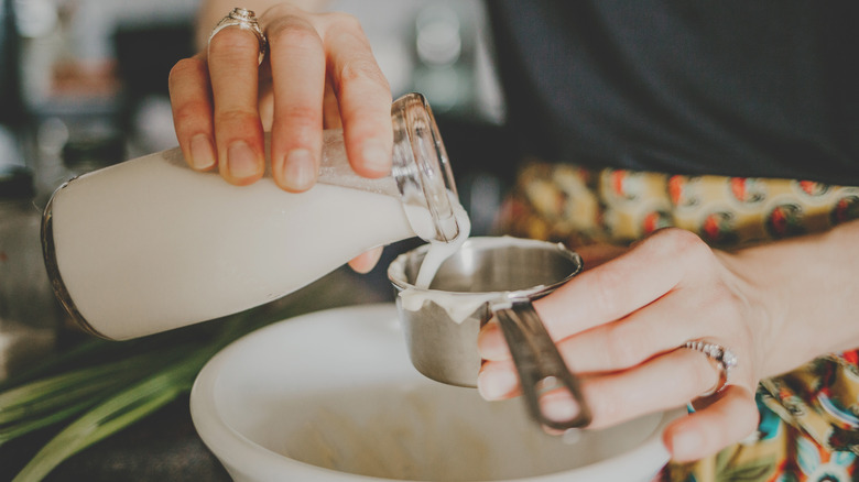 Buttermilk pouring into measuring cup 