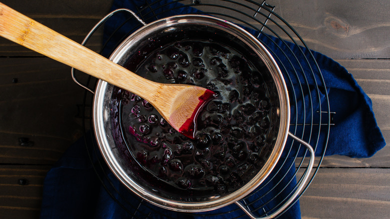 Blueberry syrup and wooden spoon in pan