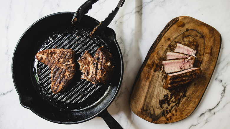 Coated tuna steaks in pan