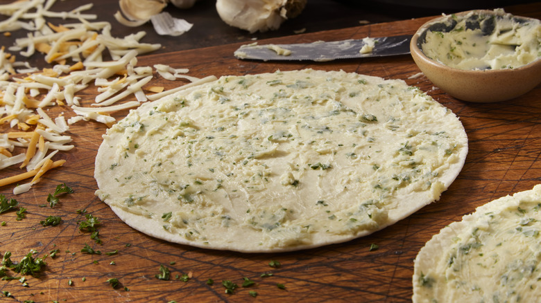 flour tortilla with compound butter and shredded cheese