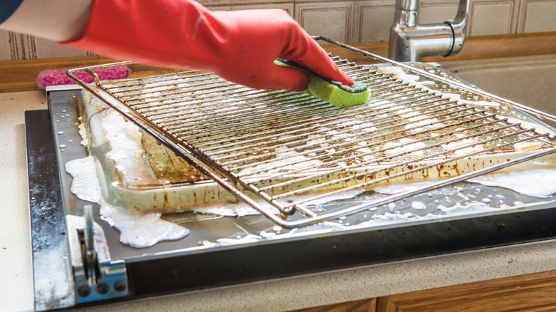 Man's hand cleaning oven rack