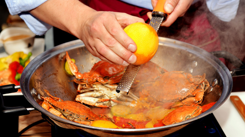 grating orange zest on crabs