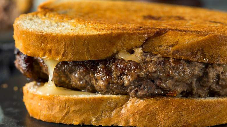 hamburger patty on grilled cheese sandwich