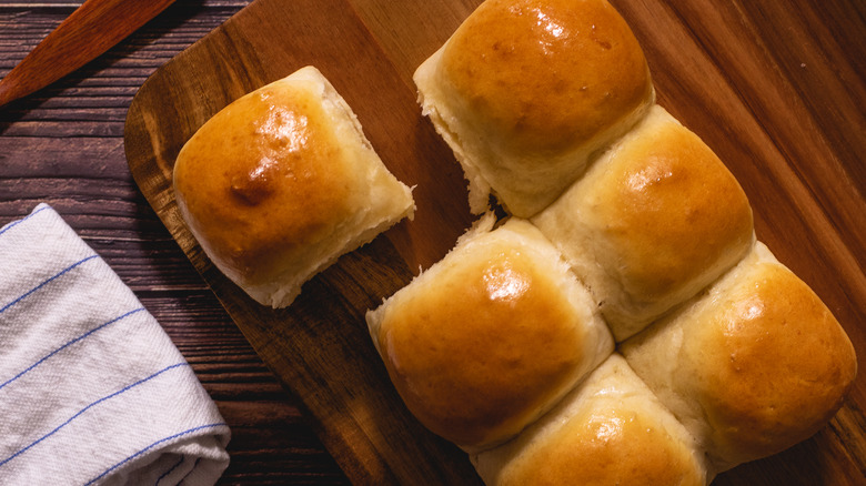 dinner rolls on a wood cutting board