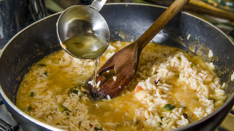 ladle of stock added to risotto