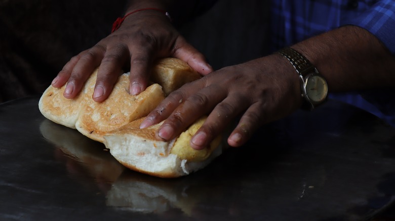 Hands toasting pav bread 